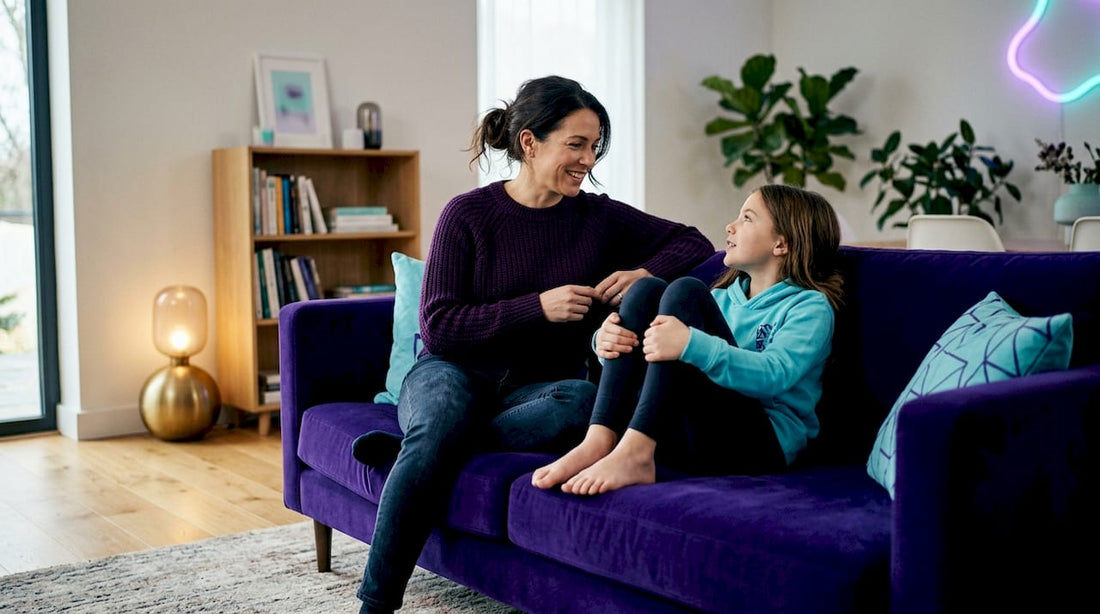 Mother and daughter talking in sunny living room
