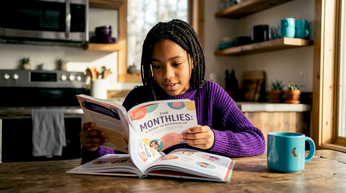 Girl reading puberty guide at kitchen table