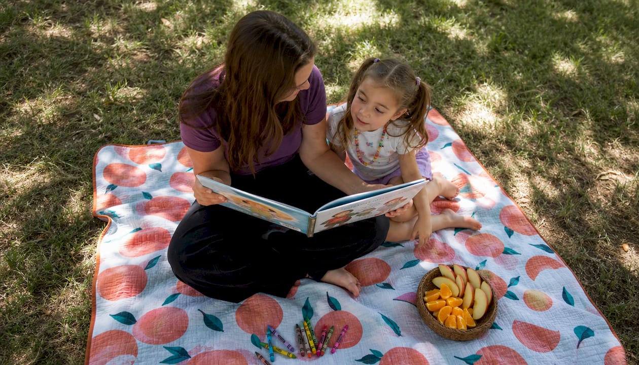 Mother reading period talk book to daughter