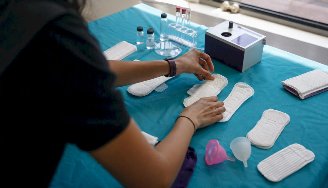 Hands holding period product samples for testing
