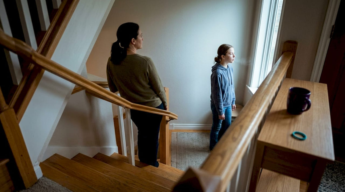 Parent and teen pausing during emotional moment